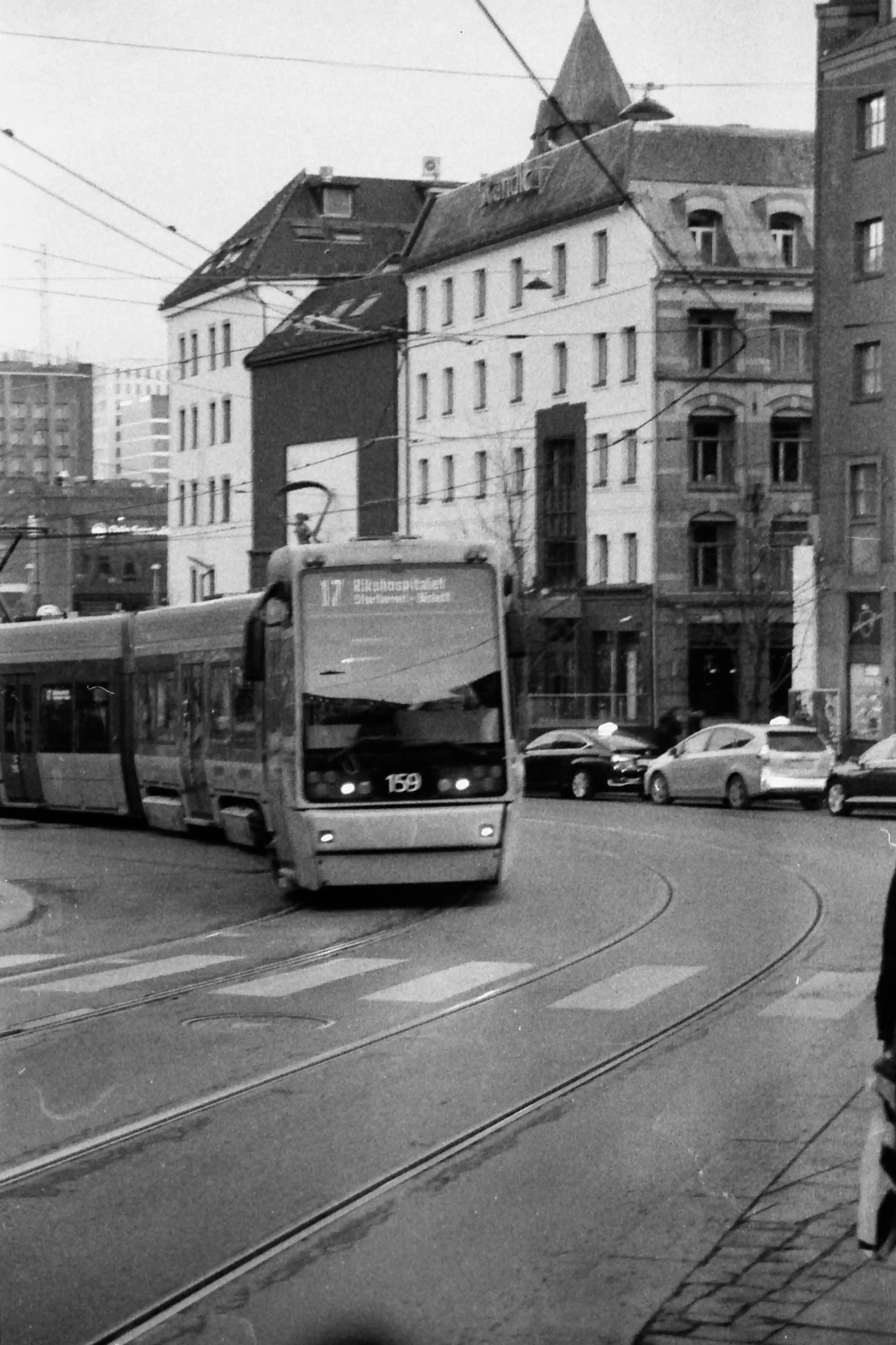 Black and white picture in portrait mode of a tram in the street. It shows on its screen that it’s line number 17 to Rikshospitalet