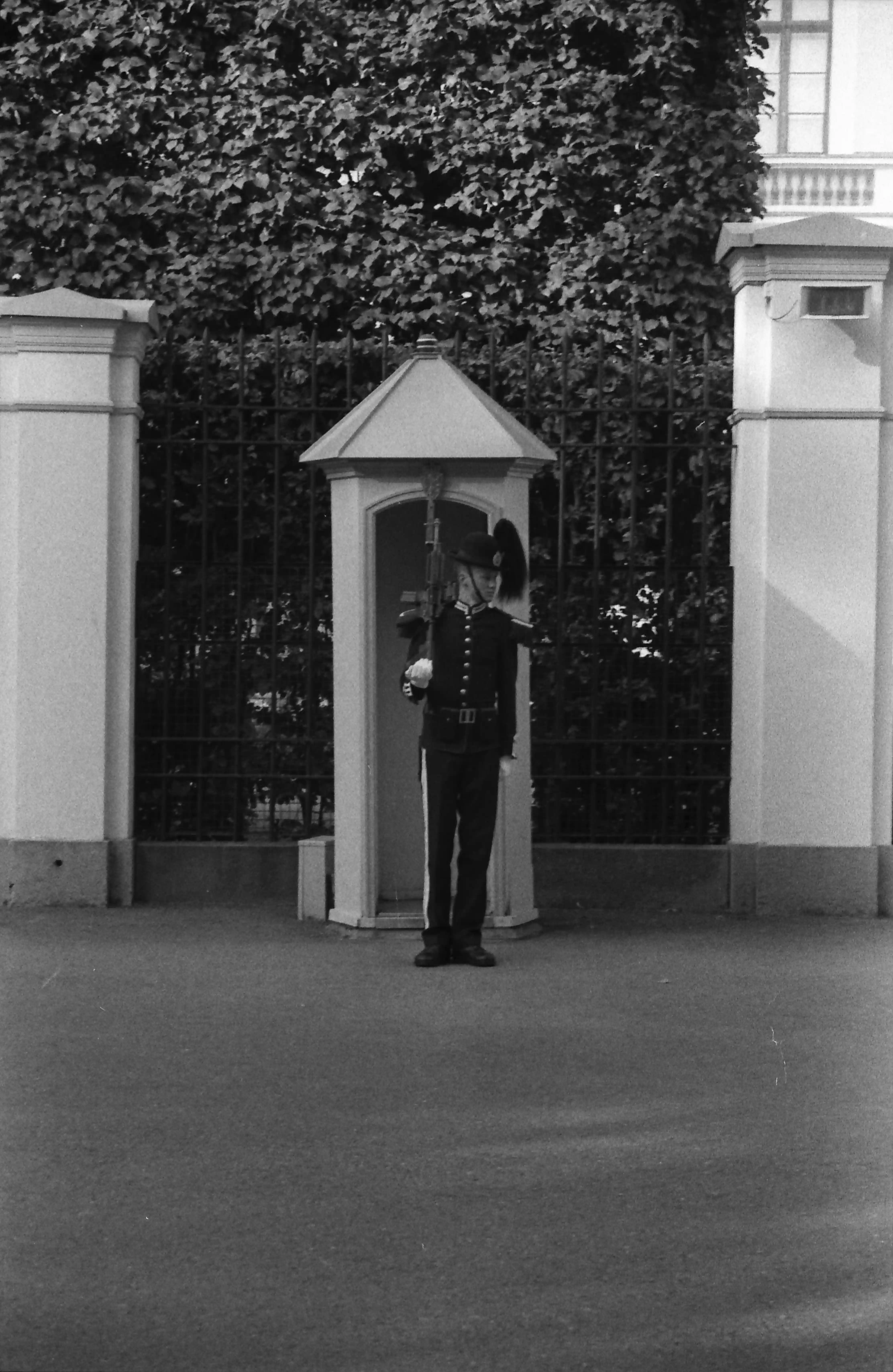 Black and white picture of a guard in front of a booth at the Royal Palace